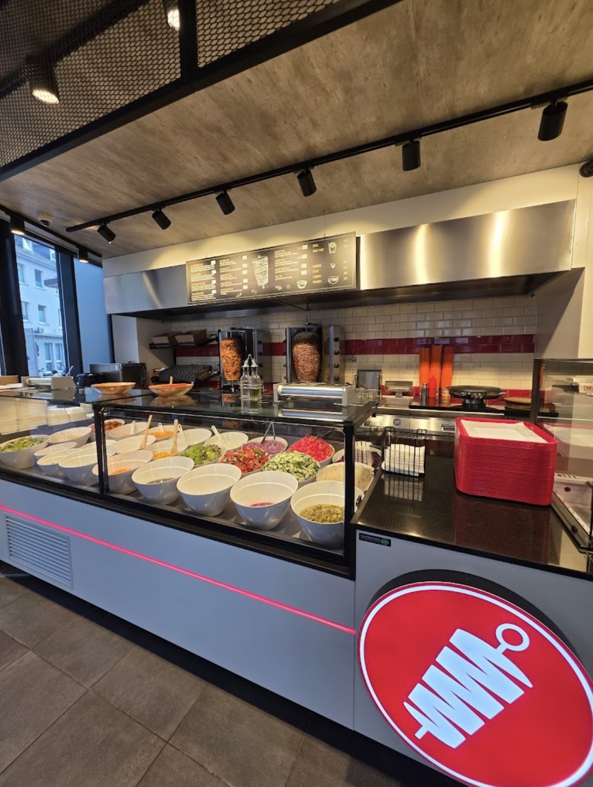 Theke mit Dönerspießen, Salatbar und Menütafel